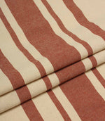 Folded cream and terracotta striped upholstery fabric showing the bold stripe repeat and soft woven drape.