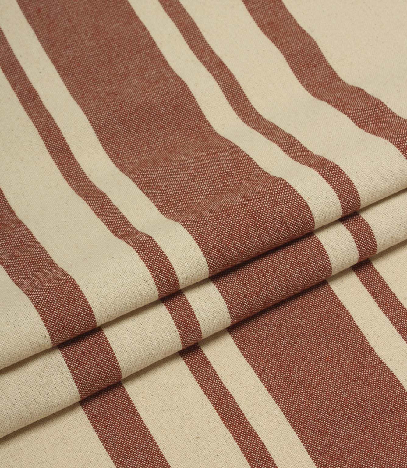 Folded cream and terracotta striped upholstery fabric showing the bold stripe repeat and soft woven drape.