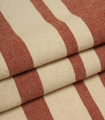 Detailed close-up of folded cream and terracotta striped fabric with textured weave and contrasting stripe design.