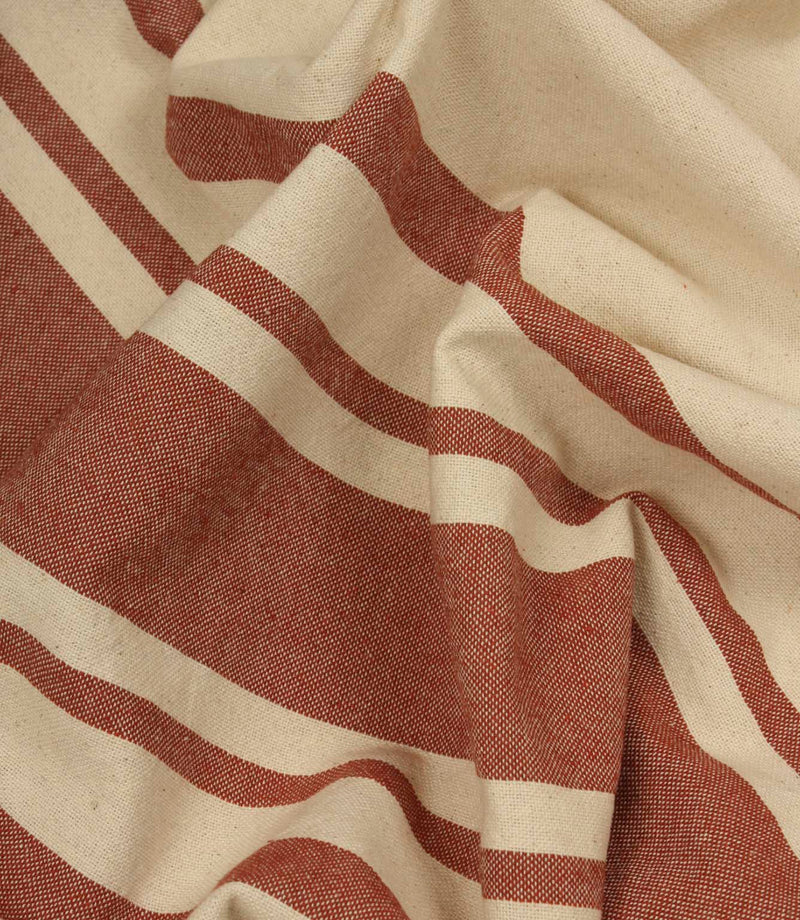 Gathered cream and terracotta striped fabric highlighting the soft drape and relaxed woven texture.