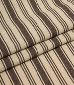 Folded cream and brown striped upholstery fabric showing the repeating stripe pattern and soft woven texture.