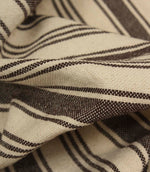 Macro close-up of cream and brown striped woven fabric showing the tactile texture and fine stripe detailing.
