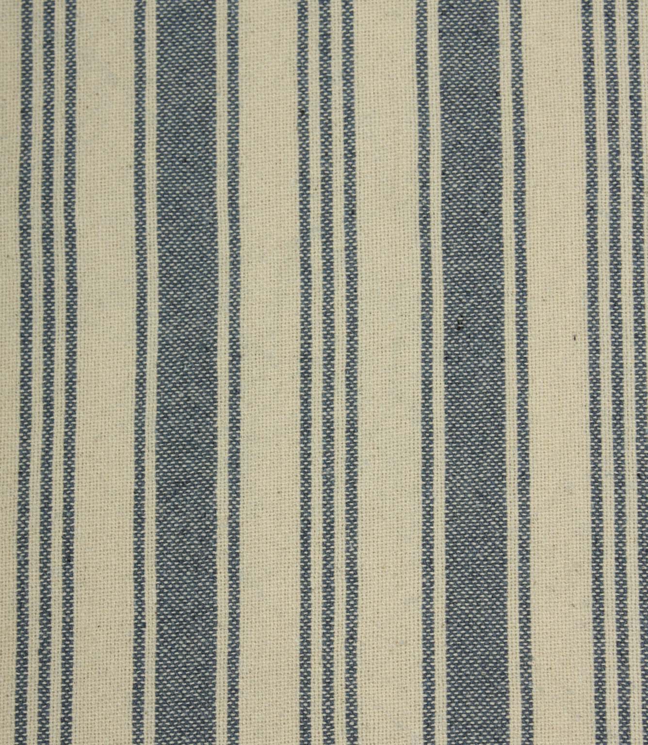 Close-up of blue striped upholstery fabric with textured weave detail, combining bold denim-blue stripes and narrow pinstripes on a natural cream background.