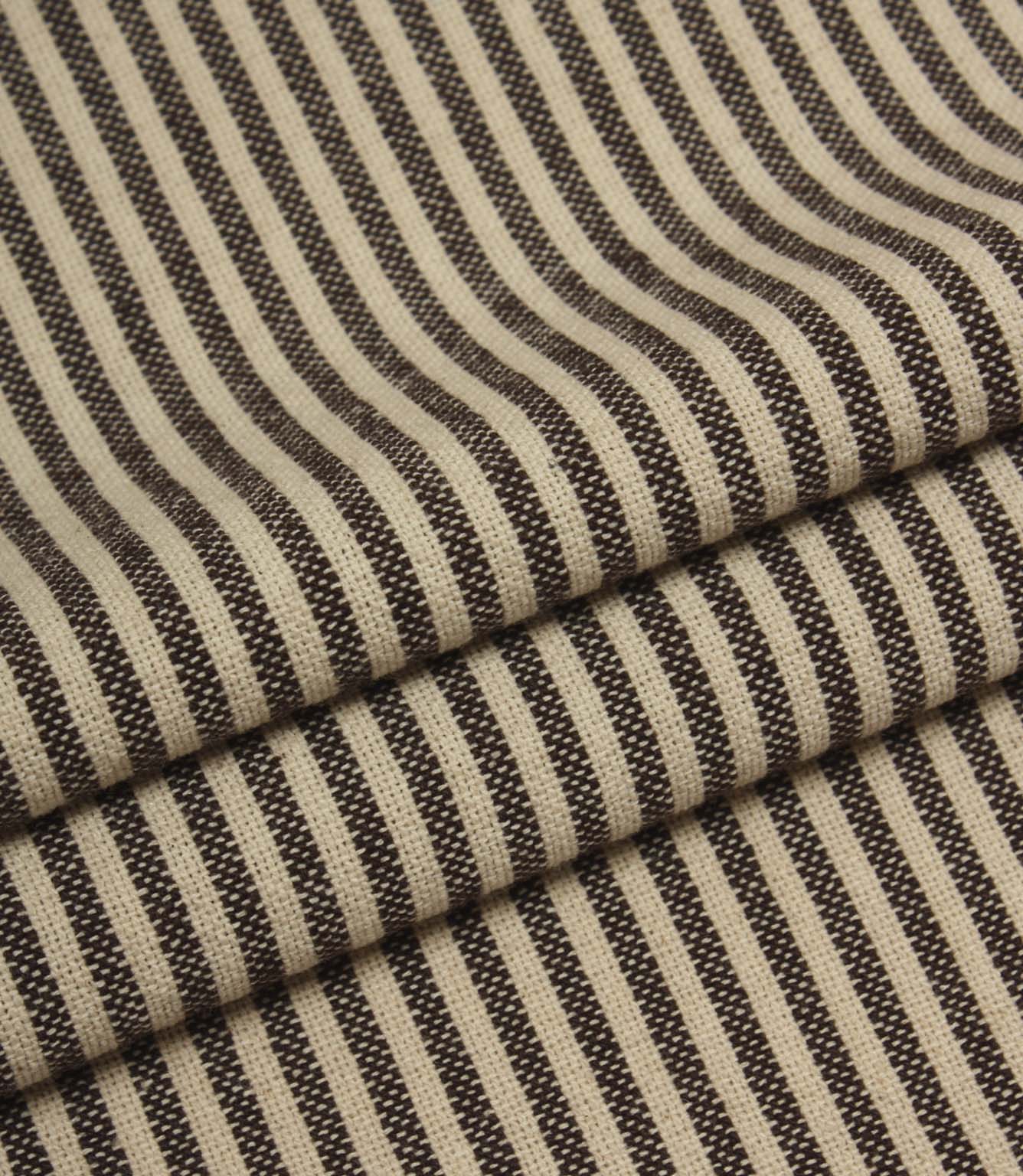 Folded striped fabric in dark brown and cream tones highlighting the soft woven finish.