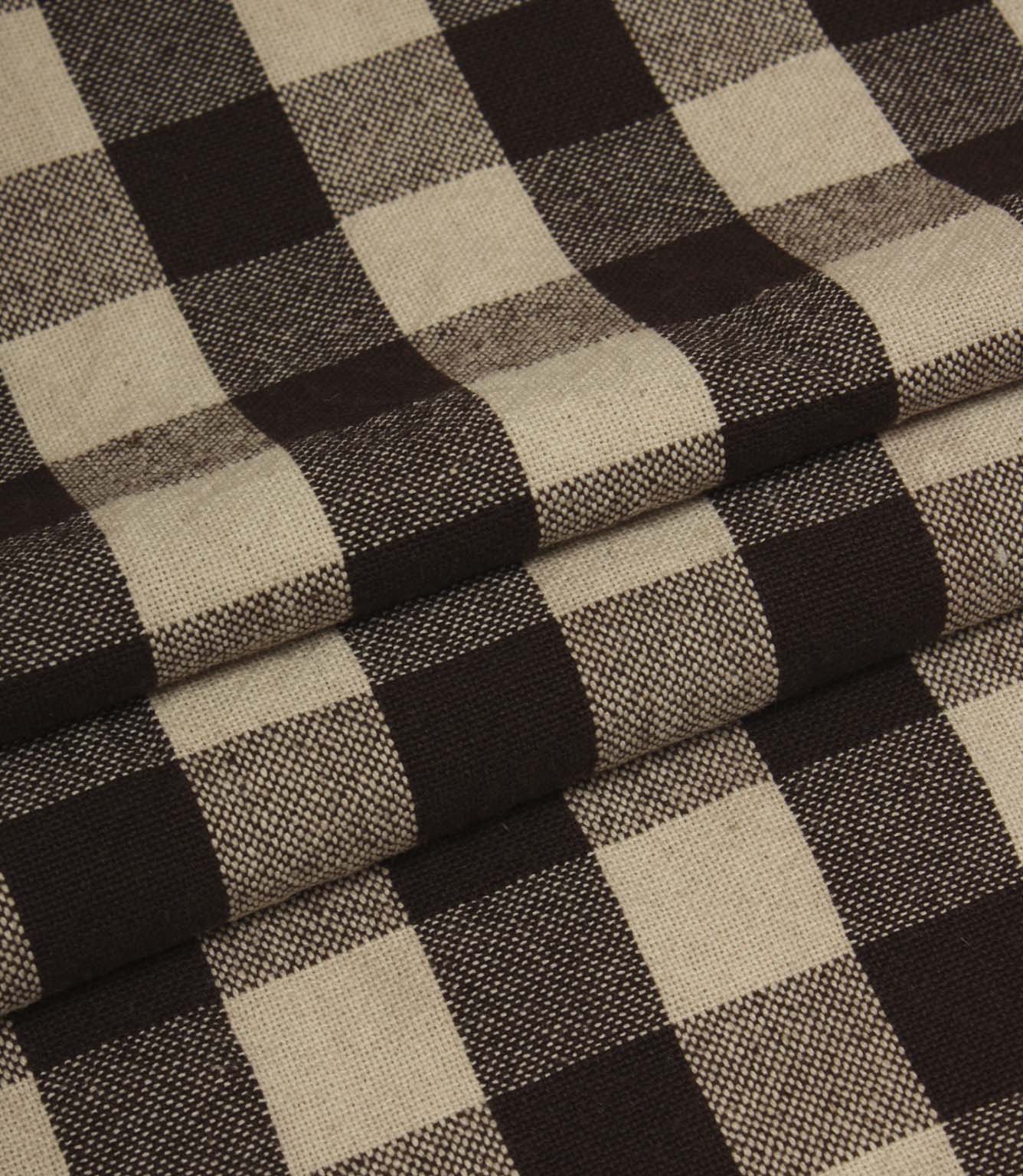 Folded gingham fabric in rich brown and cream tones showing the structured woven pattern.