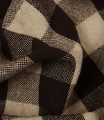 Detailed close-up of woven gingham fabric featuring bold brown and cream check squares.