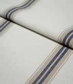 Folded Alma Stripe Marina fabric showing the off-white woven ground with repeating navy blue and natural beige stripes and a tactile textured finish.