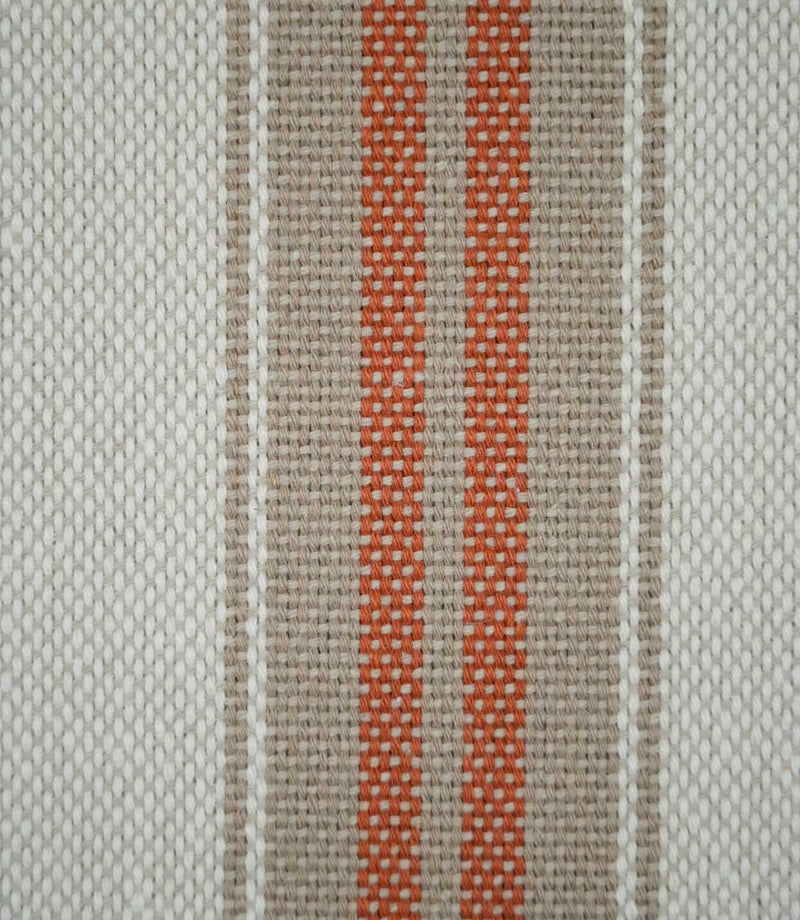 Close-up of Alma Stripe Terracotta fabric showing the textured weave with twin terracotta stripes set within a natural beige band on an off-white ground.