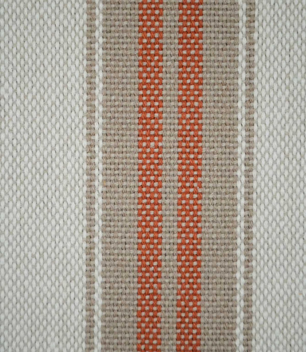Close-up of Alma Stripe Terracotta fabric showing the textured weave with twin terracotta stripes set within a natural beige band on an off-white ground.