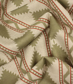 Softly gathered sage and cream geometric upholstery fabric displaying the woven texture, natural drape, and decorative Southwestern-inspired motif.
