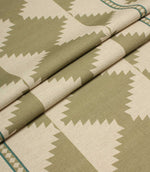 Folded fabric with geometric pattern in green and beige tones