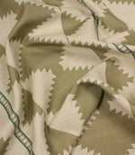 Fabric with a geometric pattern in green and beige tones