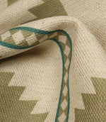Close-up of a woven fabric with geometric pattern and green thread