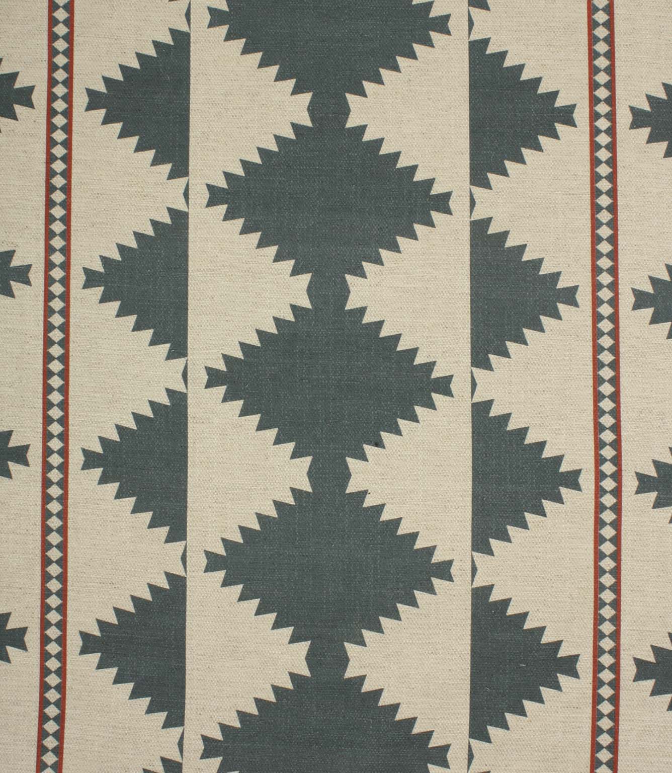 Cream woven fabric with a bold geometric tribal-inspired pattern in muted teal and rust red, featuring repeating diamond motifs and decorative border stripes.
