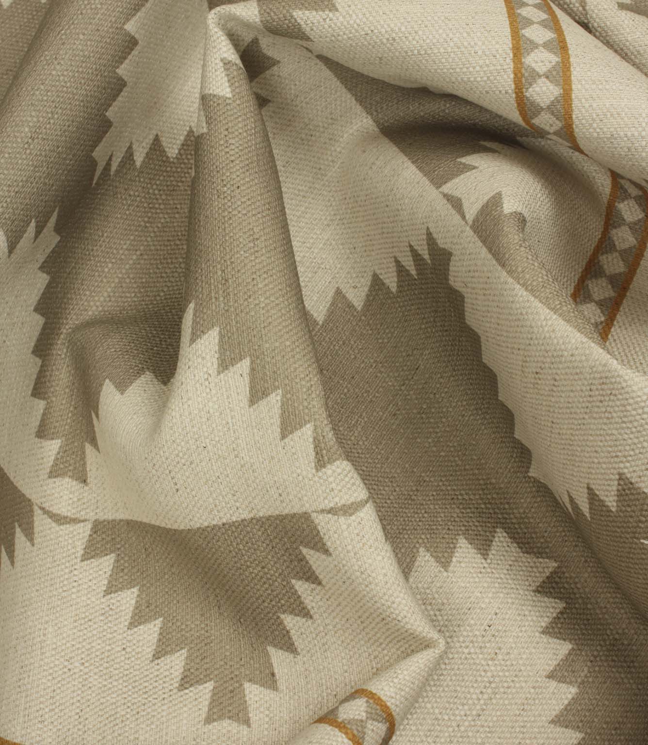 Macro close-up of woven cream fabric highlighting the textured weave, taupe geometric border pattern, and warm ochre accent stripes.