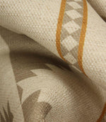 Close-up of cream woven fabric showing the soft drape, textured surface, taupe geometric motif and warm ochre border stripe detail.