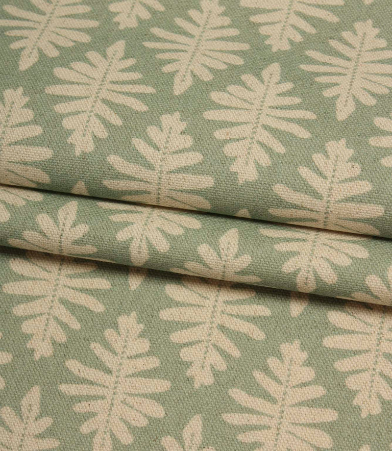 Folded Ashleaf Dill fabric displaying the textured weave and repeating botanical leaf motif.