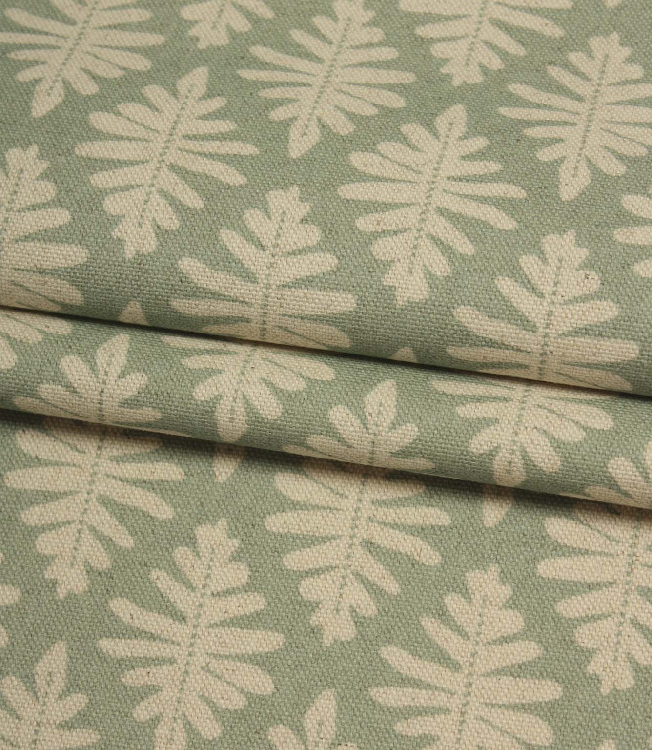 Folded Ashleaf Dill fabric displaying the textured weave and repeating botanical leaf motif.
