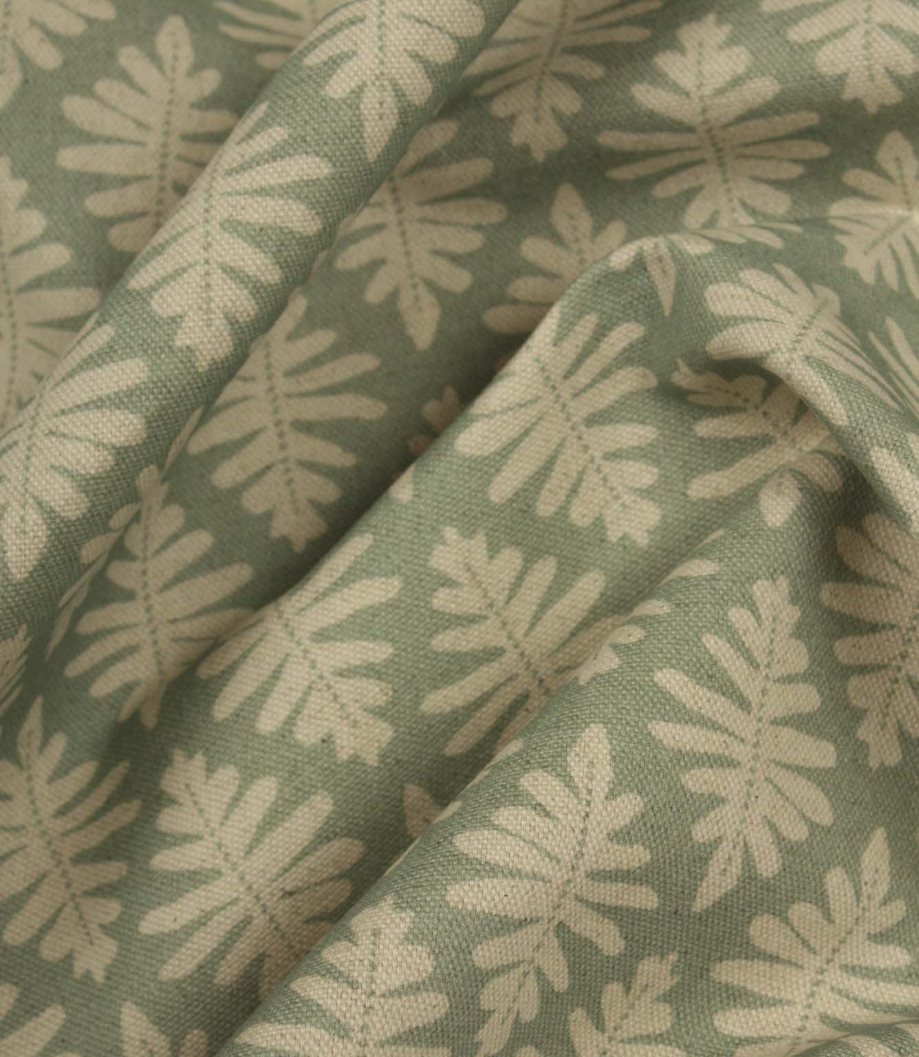 Draped Ashleaf Dill fabric showing the natural flow and soft sage green leaf pattern.