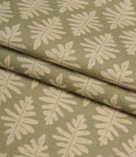 Folded Ashleaf Lemon Grass woven fabric highlighting the texture, drape and small-scale foliage design.