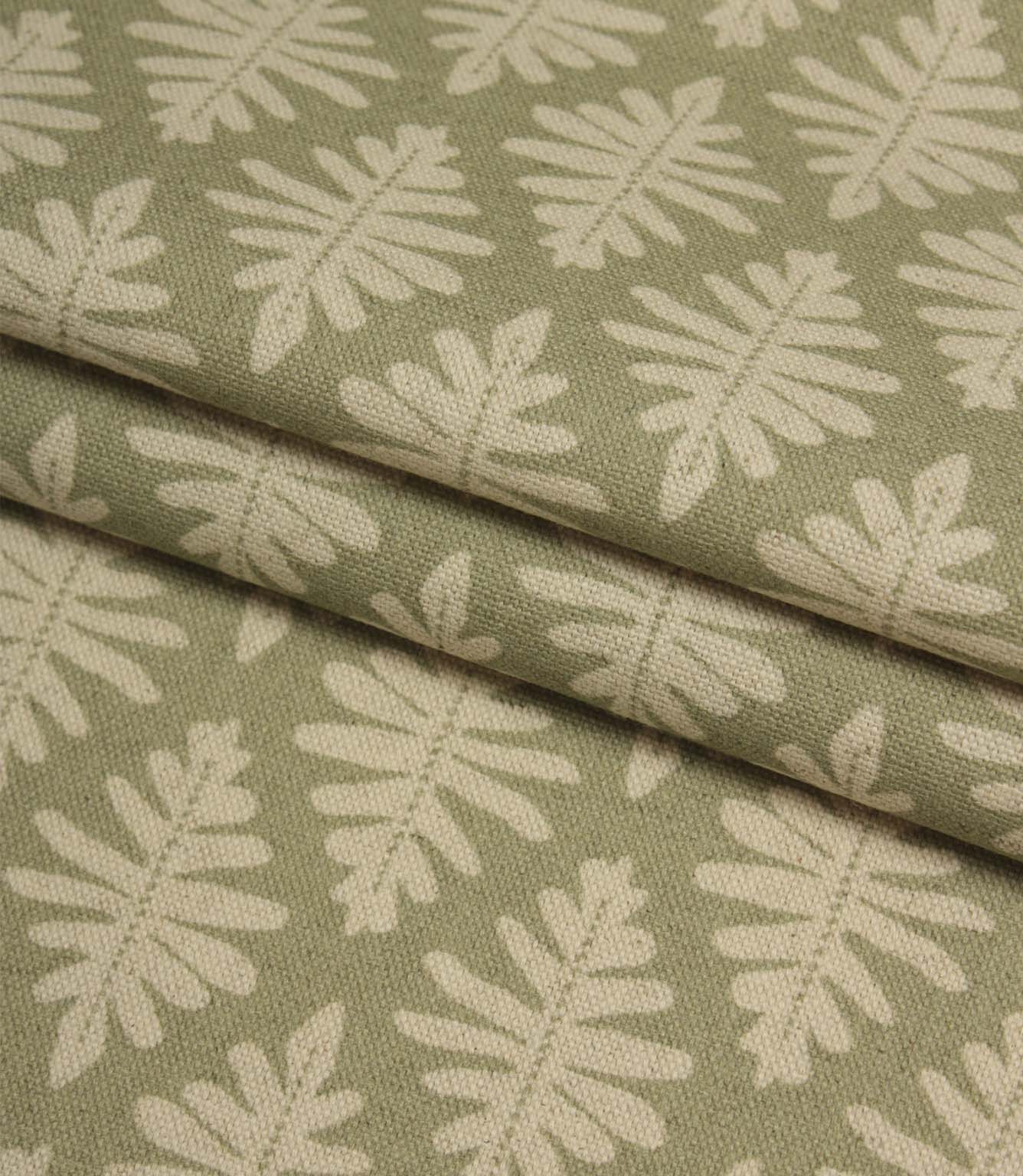 Folded Ashleaf Lemon Grass woven fabric highlighting the texture, drape and small-scale foliage design.