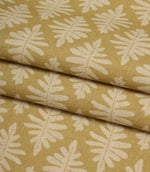 Folded Ashleaf Pesto woven fabric highlighting the texture, drape and small-scale foliage design.