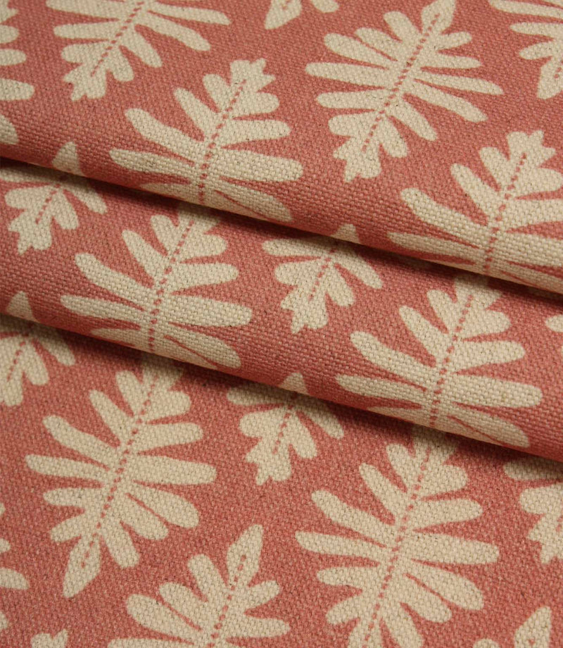 Folded Ashleaf Raspberry woven fabric showing the texture, depth and scale of the contemporary leaf design.
