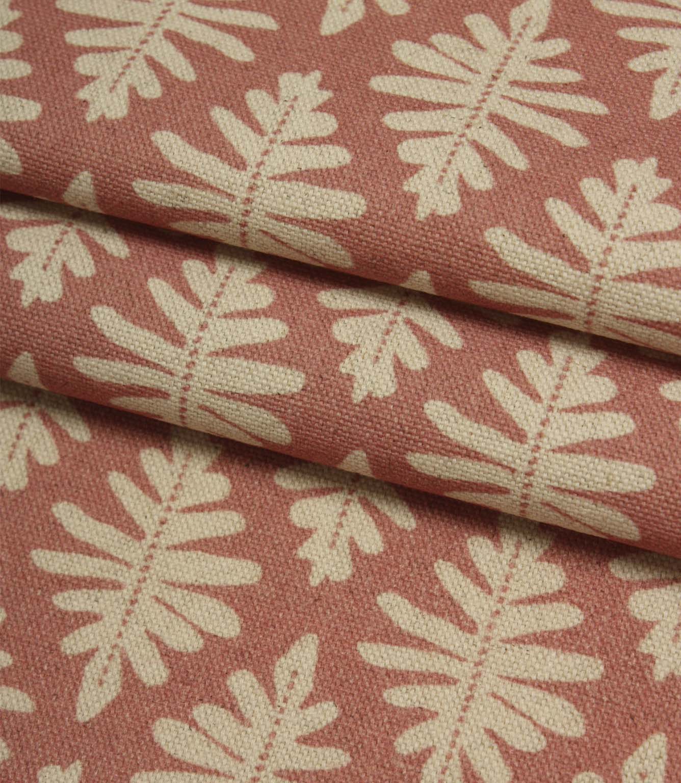 Folded Ashleaf Raspberry woven fabric showing the texture, depth and scale of the contemporary leaf design.