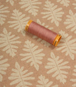 Ashleaf Tuskan Pink fabric with a coordinating pink thread spool, highlighting colour matching and pattern detail.