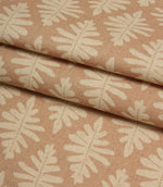 Folded Ashleaf Tuskan Pink fabric displaying the woven texture and contemporary cream leaf design.