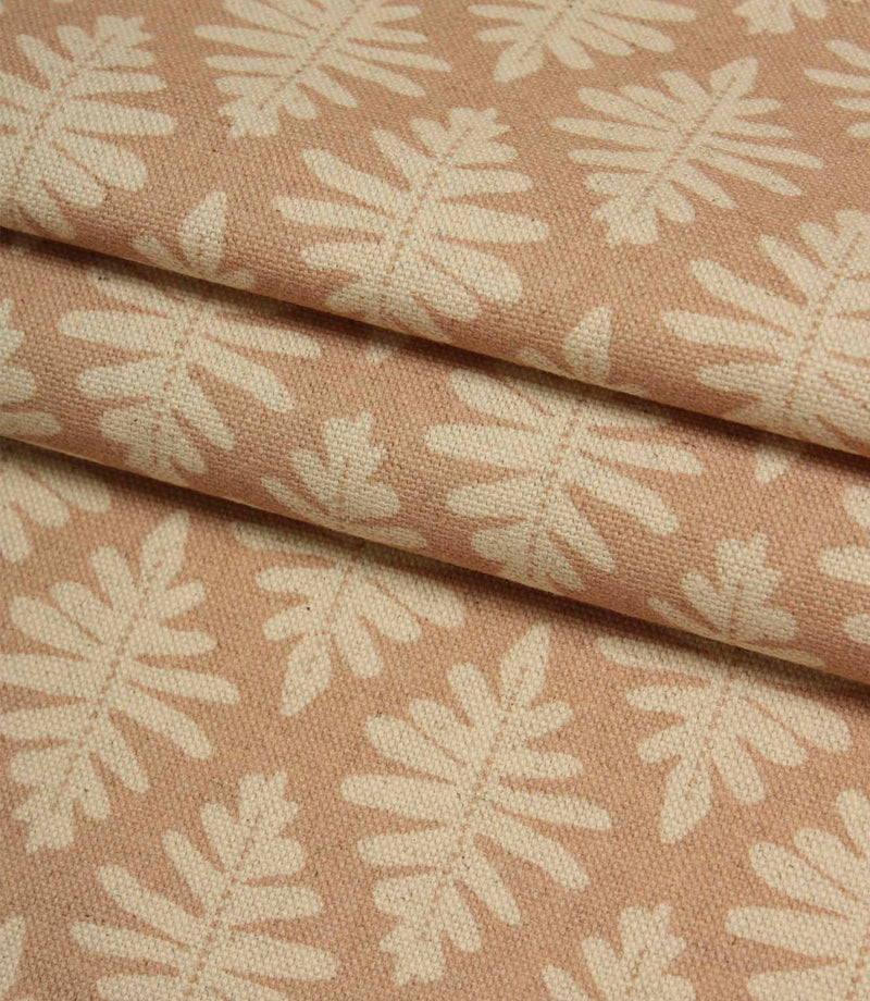 Folded Ashleaf Tuskan Pink fabric displaying the woven texture and contemporary cream leaf design.