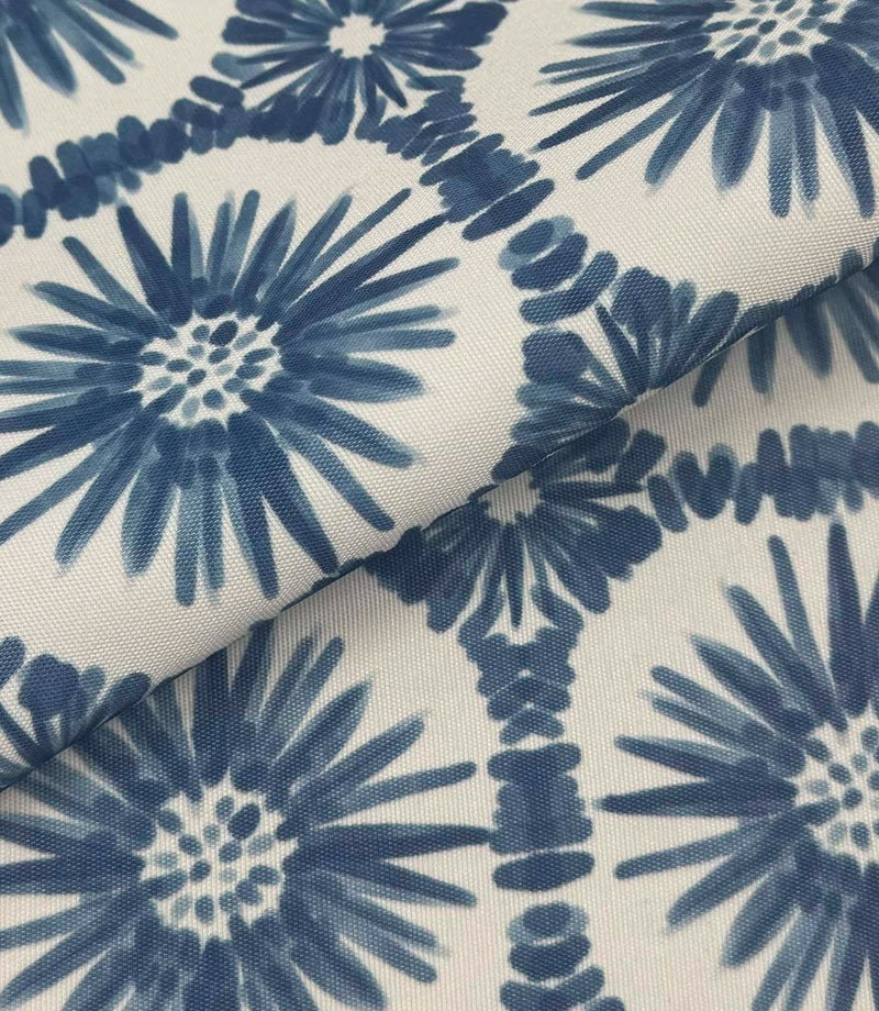 Folded Atlantic Flower outdoor fabric featuring navy blue floral motifs on an off-white background with geometric detailing.