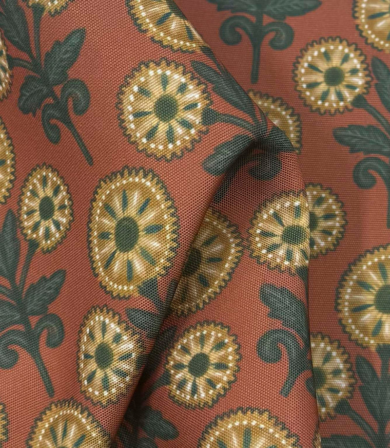 Draped Autumn Sunflower outdoor fabric showing a folk-inspired botanical design in warm rust, olive green, cream, and golden yellow shades.