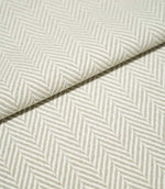 Close-up of folded Bampton Argent herringbone fabric, showing its substantial woven texture, thickness and repeating soft grey and off-white chevron design.