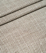 Bampton Bison herringbone fabric arranged in layered folds, displaying the structured texture and repeating chocolate brown and off-white woven chevron design.