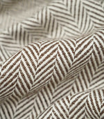 Macro close-up of draped Bampton Bison herringbone fabric, highlighting the individual woven fibres, raised texture and detailed chocolate brown and off-white chevron design.