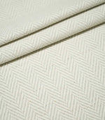 Layered folds of Bampton Elephant Grey herringbone fabric, highlighting the repeating neutral chevron pattern, textured weave and fabric thickness.