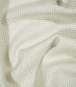 Bampton Elephant Grey herringbone fabric loosely draped and gathered, demonstrating its natural movement, soft neutral colouring and woven chevron design.