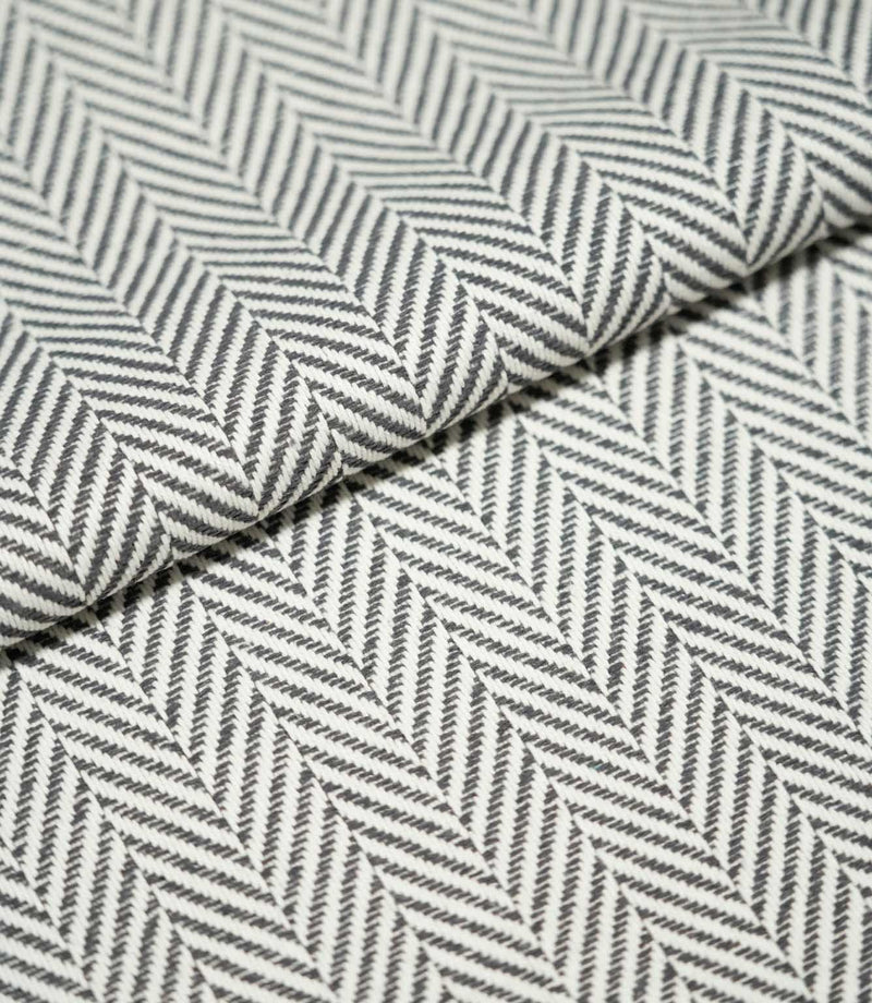 Close-up of folded Bampton Grey herringbone fabric, highlighting the structured woven texture, grey and off-white chevron pattern and fabric thickness.