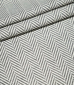 Bampton Grey herringbone upholstery fabric arranged in neat folds, showing the repeating grey and off-white woven pattern and substantial textured finish.