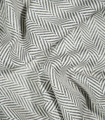Bampton Grey herringbone fabric loosely draped and gathered, demonstrating how the textured woven material falls naturally while retaining its distinctive chevron pattern.