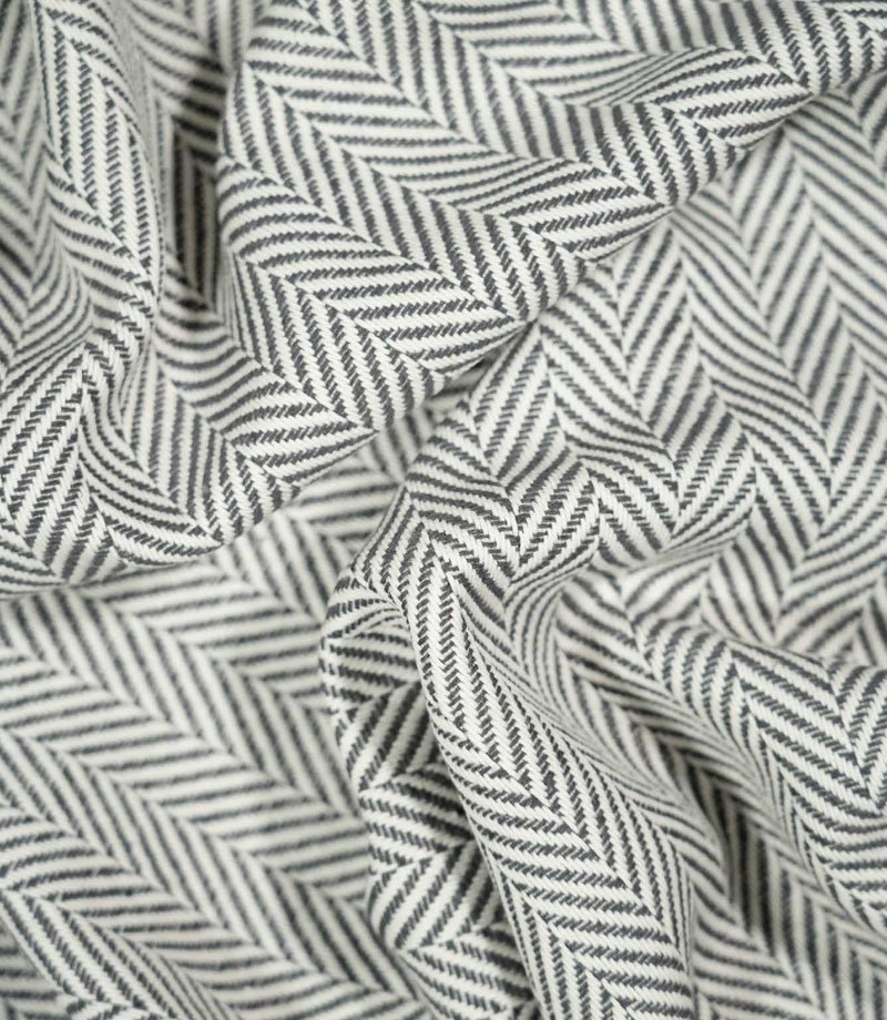 Bampton Grey herringbone fabric loosely draped and gathered, demonstrating how the textured woven material falls naturally while retaining its distinctive chevron pattern.
