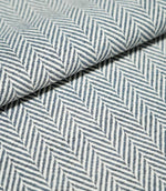 Close-up of folded Bampton Ink herringbone fabric, showing its substantial woven texture and repeating navy blue and off-white chevron design.