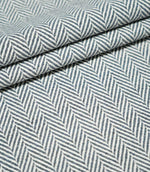 Layered folds of Bampton Ink herringbone fabric, highlighting the structured weave, thickness and contrasting navy blue and off-white herringbone pattern.