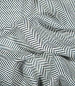Bampton Ink herringbone fabric loosely draped and gathered, demonstrating its natural movement and bold repeating navy blue and off-white chevron design.