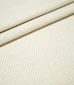 Bampton Jasmine herringbone fabric arranged in layered folds, displaying the tonal cream chevron pattern and substantial textured woven finish.