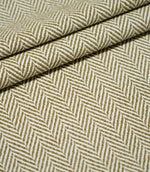 Bampton Matcha herringbone fabric arranged in layered folds, displaying the structured texture and repeating olive green and off-white woven chevron design.