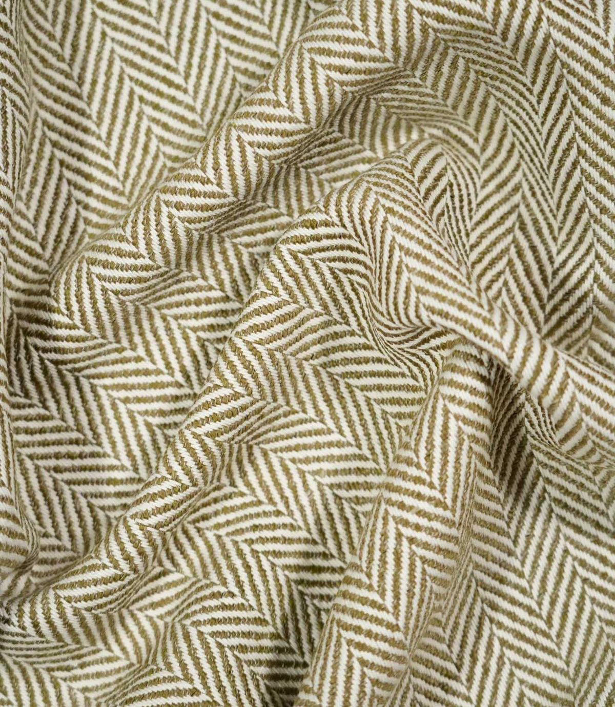 Bampton Matcha herringbone fabric loosely draped and gathered, demonstrating the natural movement of the material and its distinctive olive green and off-white chevron pattern.