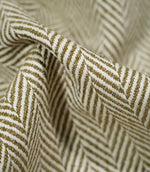 Macro close-up of draped Bampton Matcha herringbone fabric, highlighting the individual woven fibres, raised texture and detailed olive green and off-white chevron design.