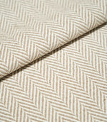 Close-up of folded Bampton Taupe herringbone fabric, showing the warm taupe and off-white chevron pattern, raised woven texture and substantial finish.